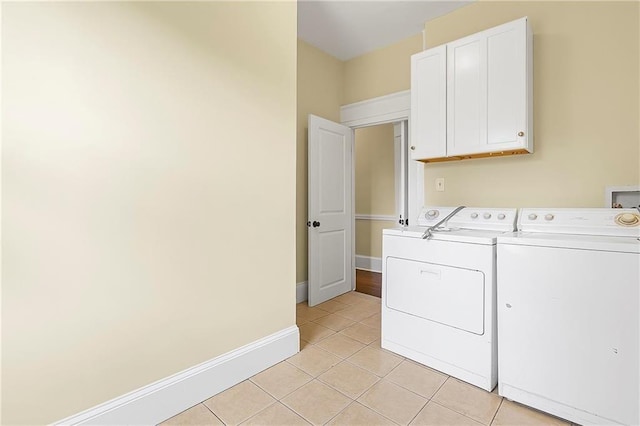 clothes washing area featuring cabinets, light tile patterned floors, and separate washer and dryer