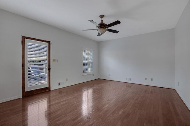 unfurnished room featuring dark wood-type flooring and ceiling fan