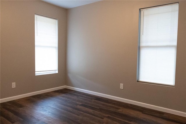 unfurnished room with dark wood-style flooring and baseboards