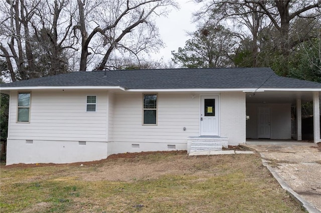 back of property featuring a yard, a shingled roof, concrete driveway, crawl space, and a carport