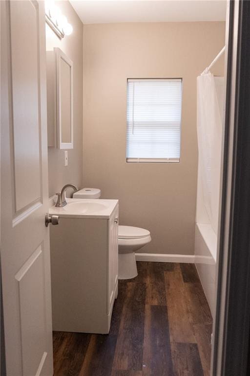 full bath with toilet, baseboards, wood finished floors, and vanity