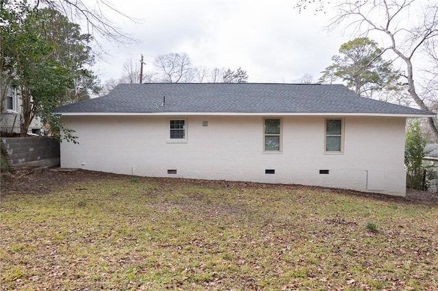 back of property with brick siding, a yard, roof with shingles, crawl space, and fence