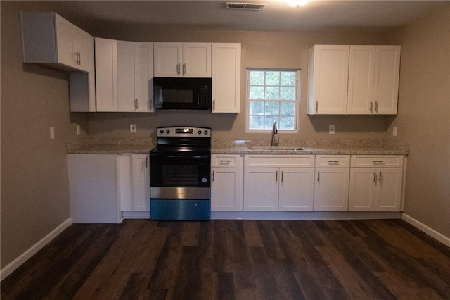 kitchen featuring black microwave, stainless steel electric range oven, a sink, and white cabinets