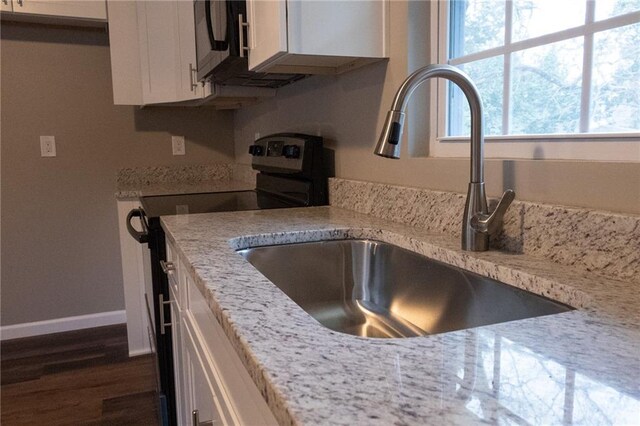 room details featuring baseboards, dark wood finished floors, white cabinets, appliances with stainless steel finishes, and a sink