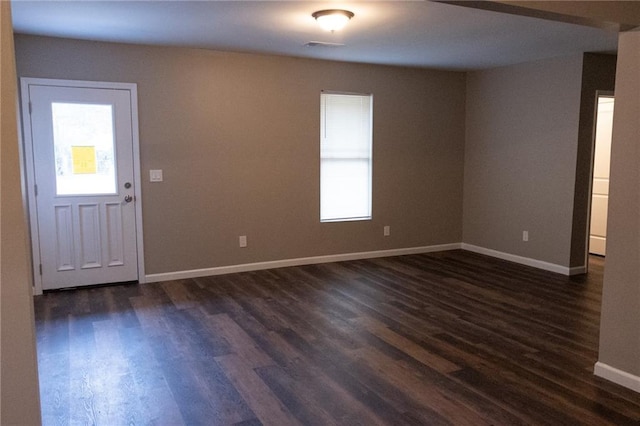 interior space featuring dark wood-style flooring and baseboards