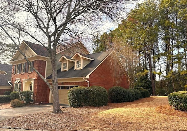 view of front of home featuring concrete driveway, a garage, and brick siding