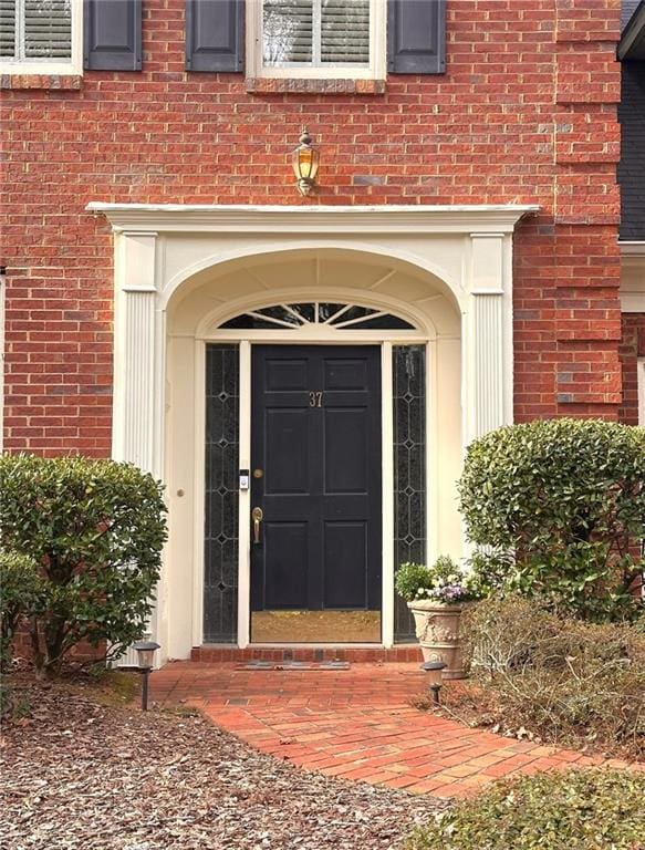 doorway to property with brick siding