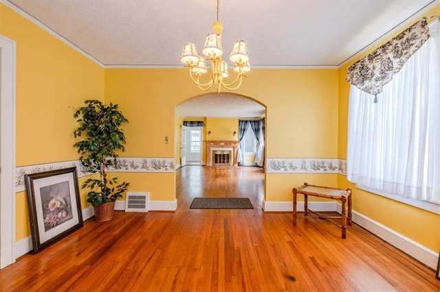 dining room with hardwood / wood-style flooring, crown molding, and a chandelier