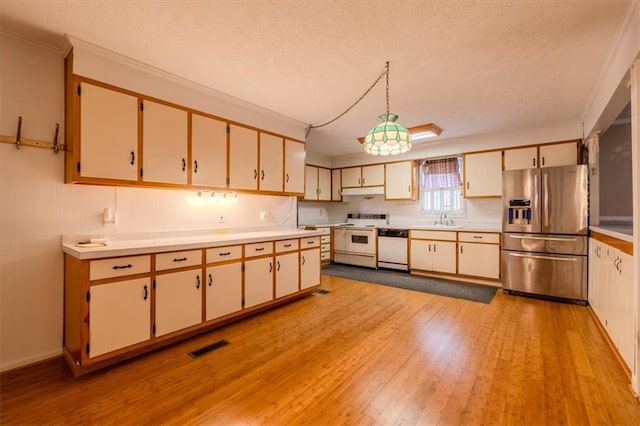 kitchen featuring white appliances, hanging light fixtures, sink, and a textured ceiling