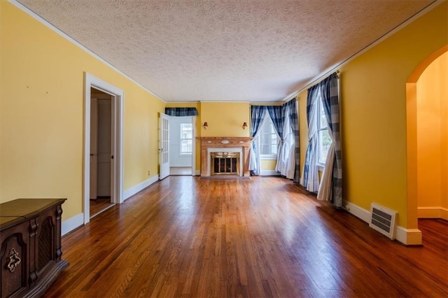 unfurnished living room featuring dark wood-type flooring and a textured ceiling