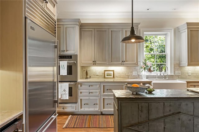 92 Old Ivy Rd NE Unit 6, Atlanta, GA 30342 - kitchen featuring stainless steel appliances, light stone counters, decorative backsplash, crown molding, and pendant lighting