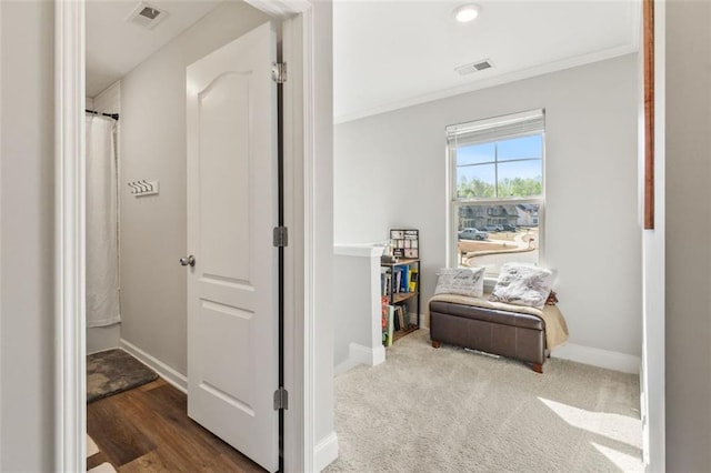 hallway with ornamental molding, baseboards, and visible vents