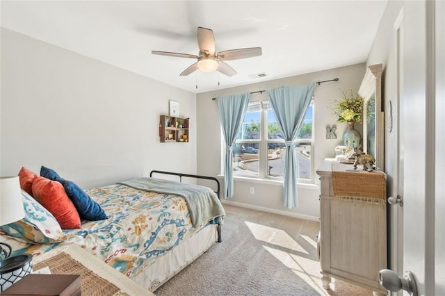 bedroom featuring light colored carpet, visible vents, baseboards, and a ceiling fan