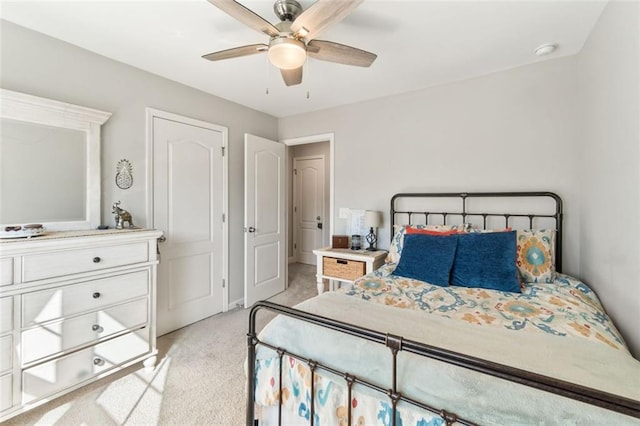 bedroom featuring light carpet and a ceiling fan