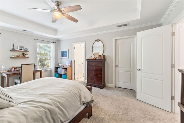 bedroom with visible vents, ornamental molding, a ceiling fan, a tray ceiling, and light colored carpet