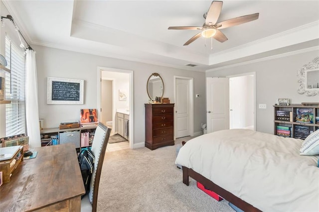 bedroom featuring ornamental molding, a raised ceiling, light carpet, and ensuite bath