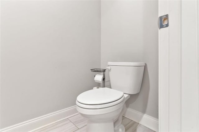 bathroom with baseboards and toilet