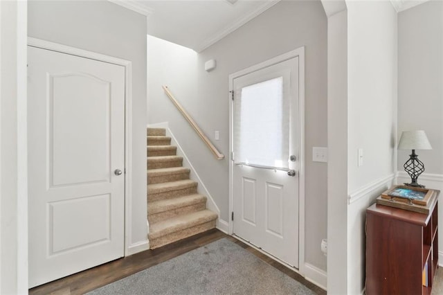foyer with stairs, wood finished floors, and ornamental molding