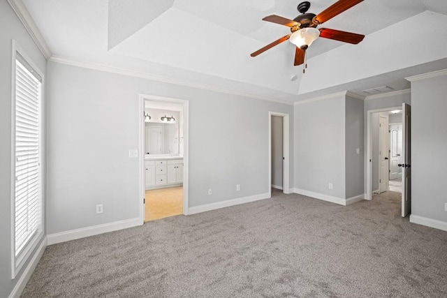 unfurnished bedroom with ornamental molding, a tray ceiling, carpet flooring, and multiple windows