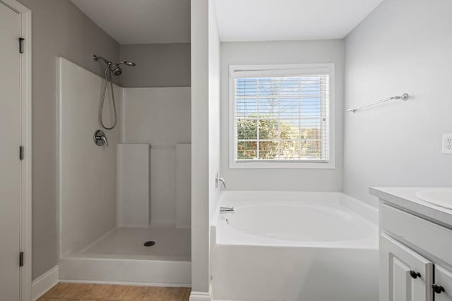 full bath with tile patterned floors, walk in shower, a bath, and vanity