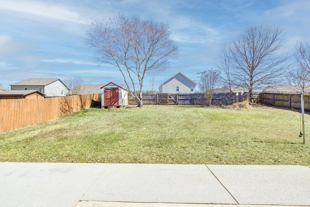 view of yard featuring an outbuilding, a fenced backyard, and a shed