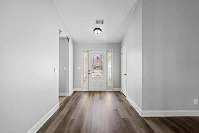 entrance foyer featuring wood finished floors, visible vents, and baseboards