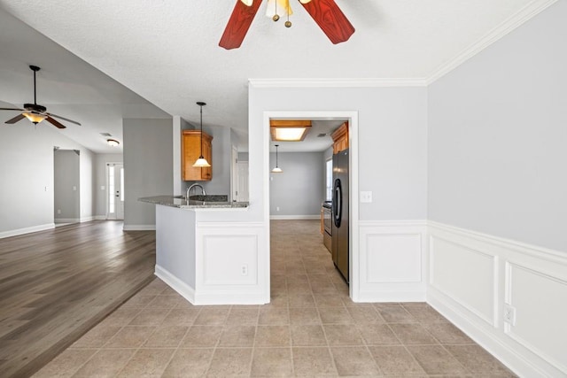 kitchen with ceiling fan, dark stone counters, open floor plan, and freestanding refrigerator