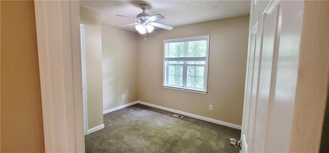 empty room with ceiling fan, a textured ceiling, and carpet flooring