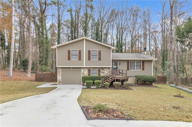 split level home featuring a garage and a front lawn