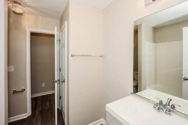 full bathroom featuring baseboards, vanity, toilet, and wood finished floors