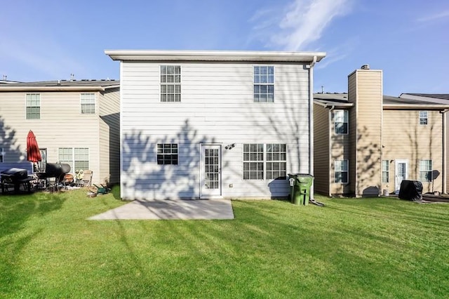 back of property featuring a patio and a lawn