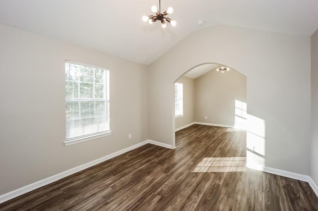 unfurnished room with dark wood-style floors, vaulted ceiling, plenty of natural light, and a notable chandelier