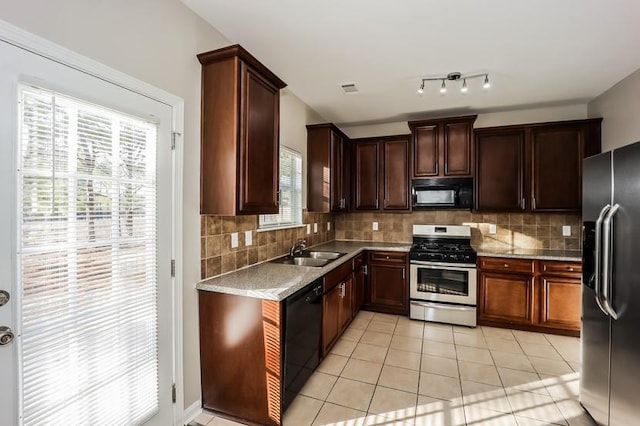 kitchen with tasteful backsplash, a sink, black appliances, and light tile patterned floors