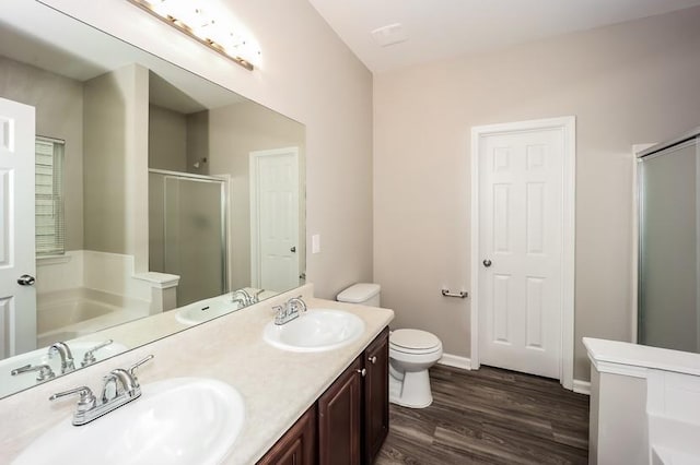 full bathroom with a garden tub, wood finished floors, a stall shower, and a sink