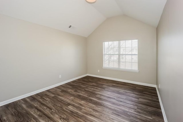 spare room featuring lofted ceiling, visible vents, dark wood finished floors, and baseboards