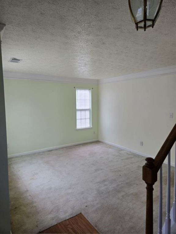 carpeted empty room with a textured ceiling and crown molding