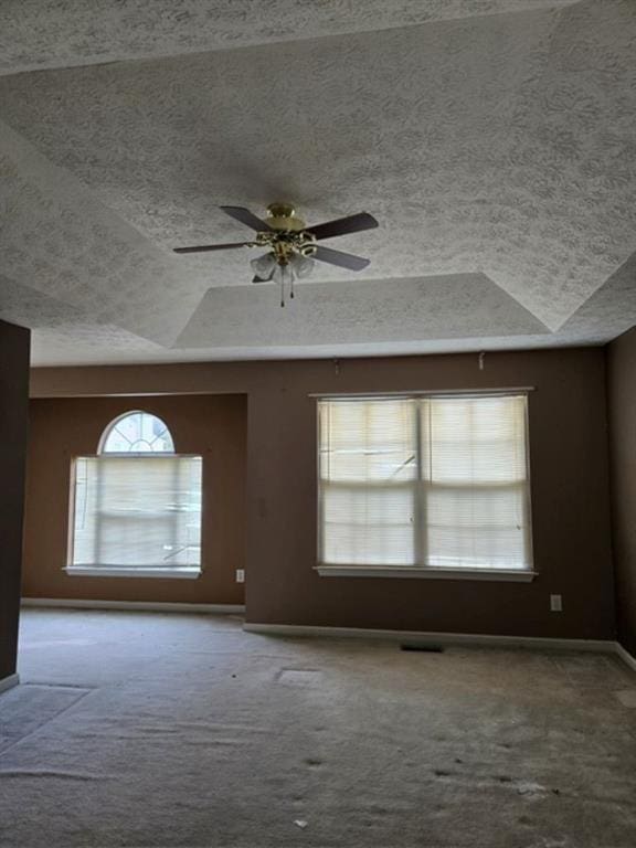 unfurnished room featuring ceiling fan, a textured ceiling, lofted ceiling, and carpet floors