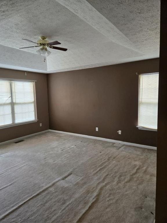 carpeted empty room with ceiling fan and a textured ceiling