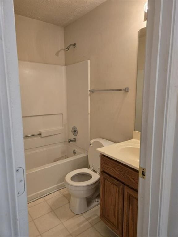 full bathroom featuring washtub / shower combination, tile patterned flooring, a textured ceiling, vanity, and toilet