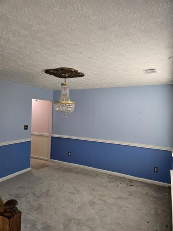 carpeted empty room featuring a textured ceiling