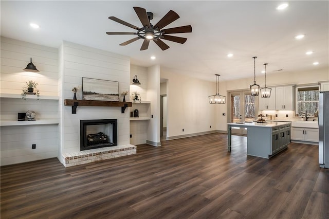 kitchen featuring dark wood-type flooring, freestanding refrigerator, open floor plan, and a breakfast bar area