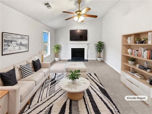 carpeted living room with vaulted ceiling and ceiling fan