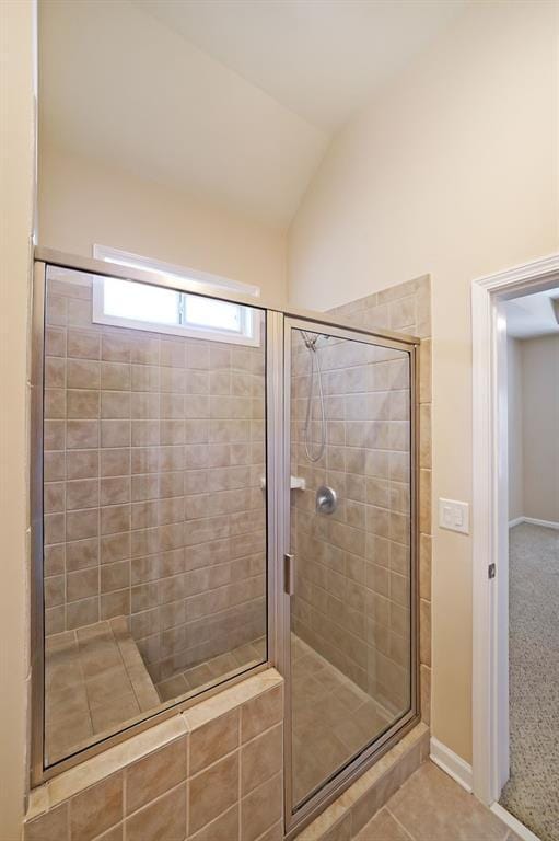 223 Glens Loop, Woodstock, GA 30188 - full bath featuring a stall shower, vaulted ceiling, baseboards, and tile patterned floors