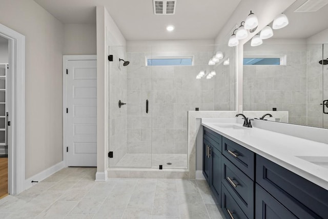 bathroom with vanity, plenty of natural light, and a shower with door