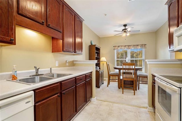 kitchen featuring ceiling fan, sink, white appliances, and light carpet