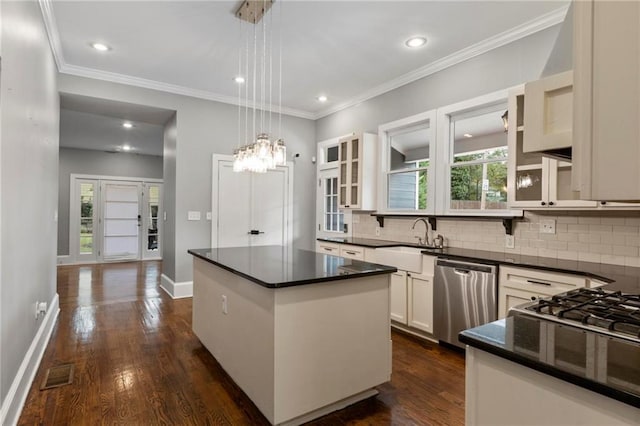 kitchen with a wealth of natural light, a center island, hanging light fixtures, and stainless steel dishwasher