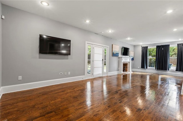 unfurnished living room with a brick fireplace and hardwood / wood-style floors