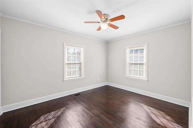 empty room featuring a wealth of natural light, crown molding, and dark hardwood / wood-style floors