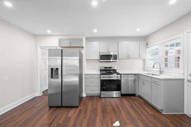 kitchen featuring gray cabinets, sink, dark wood-type flooring, and appliances with stainless steel finishes