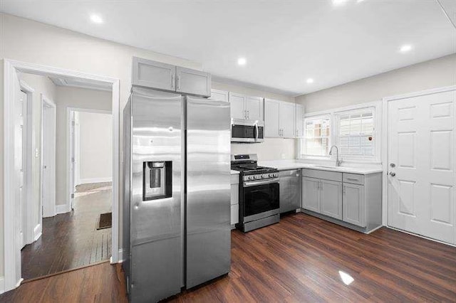 kitchen featuring gray cabinetry, dark hardwood / wood-style flooring, sink, and stainless steel appliances